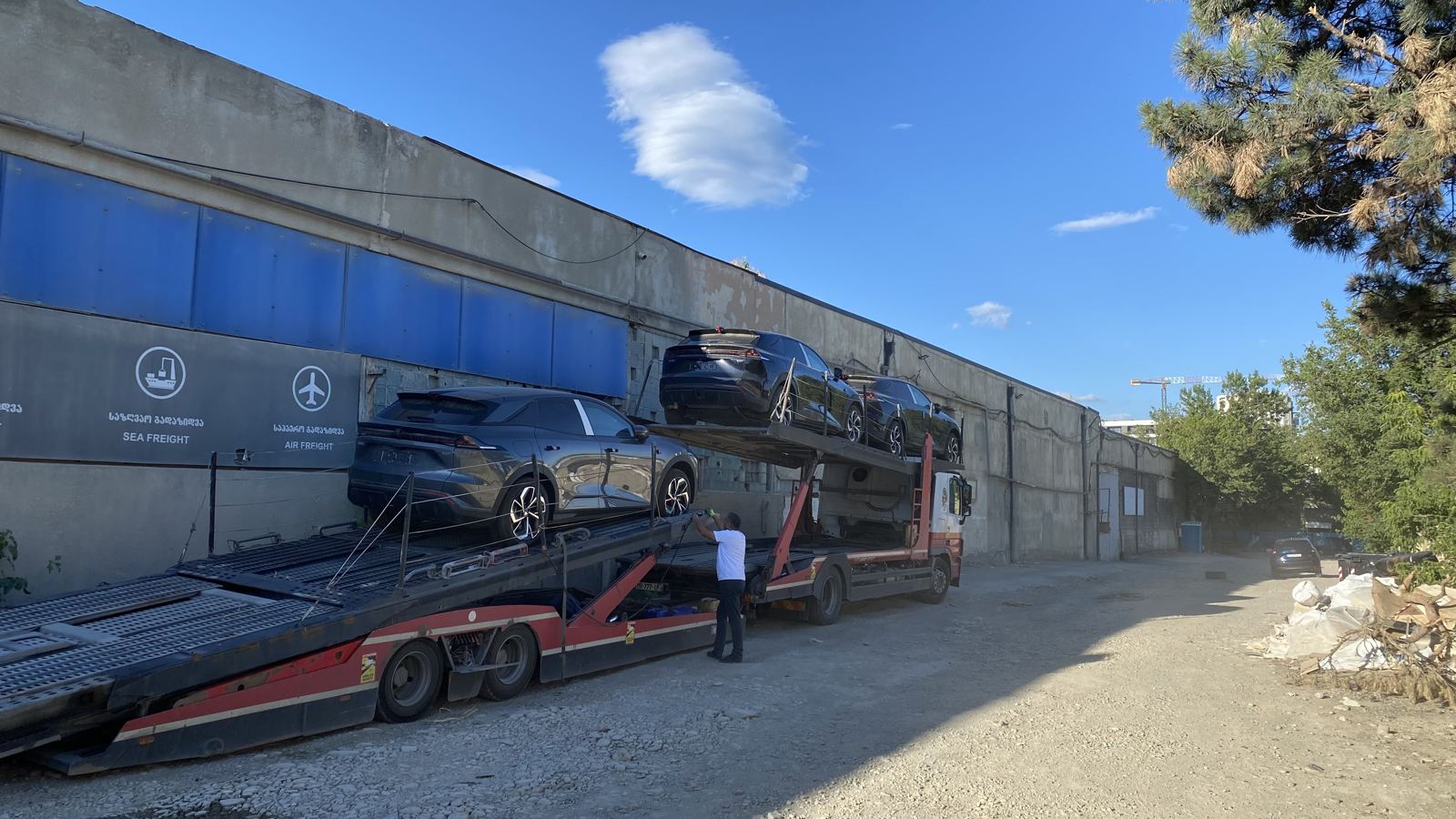New cars loaded onto a car carrier in Tbilisi