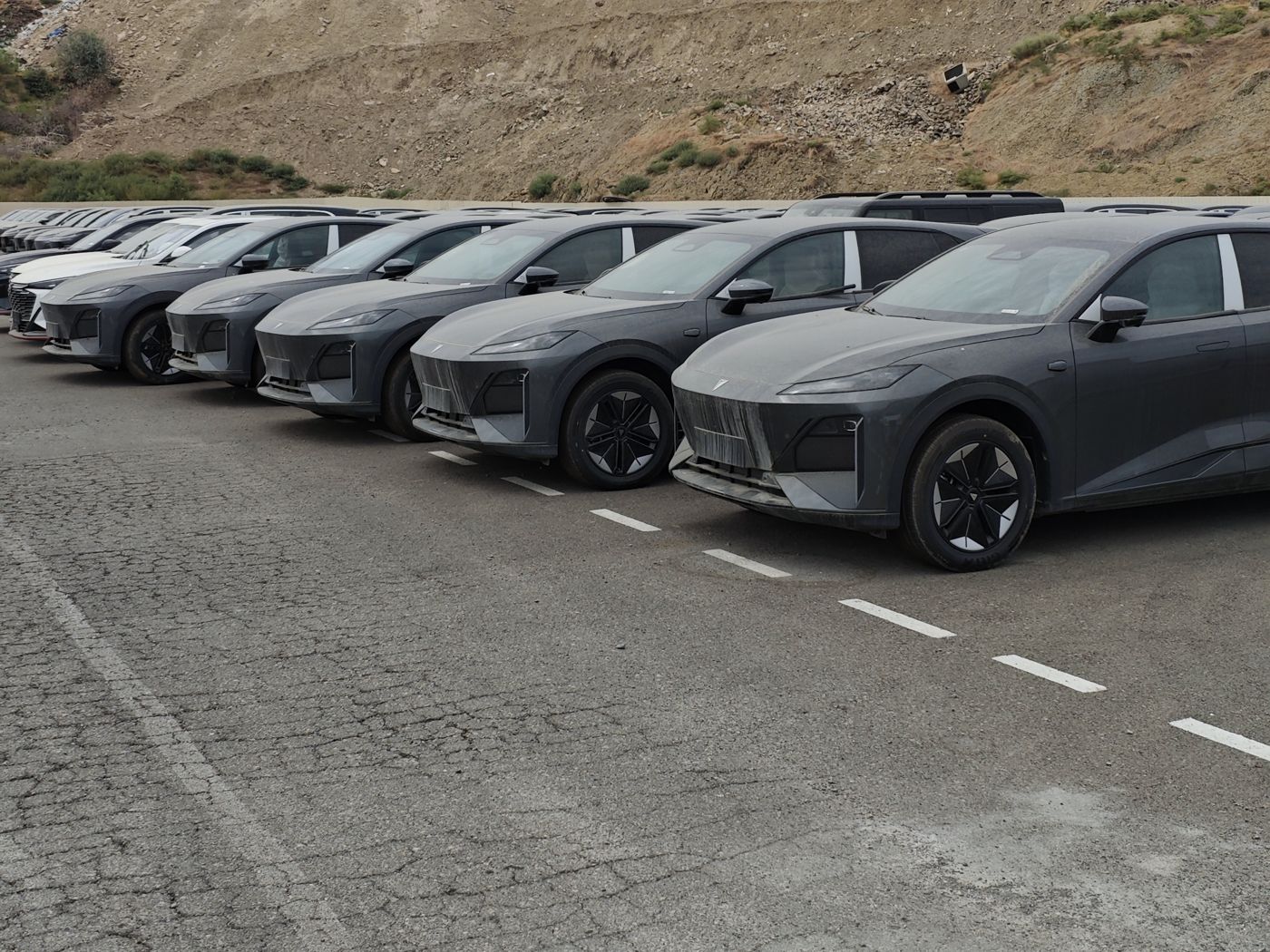 Row of new grey electric SUVs at the yard